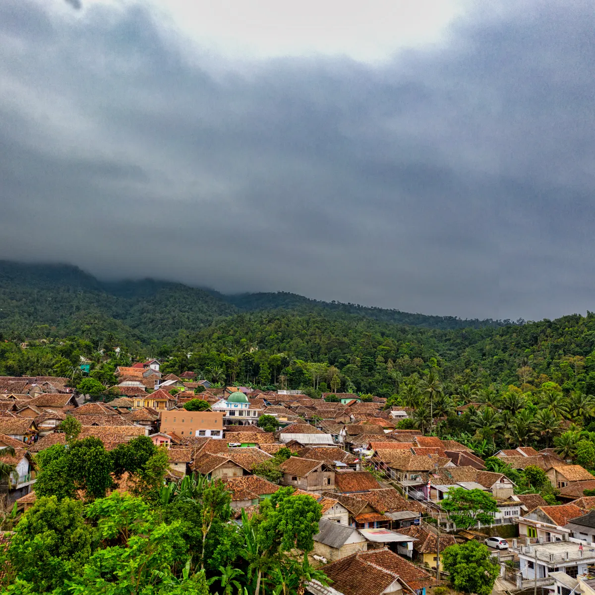 Permukiman di antara hutan tropis dengan langit berawan